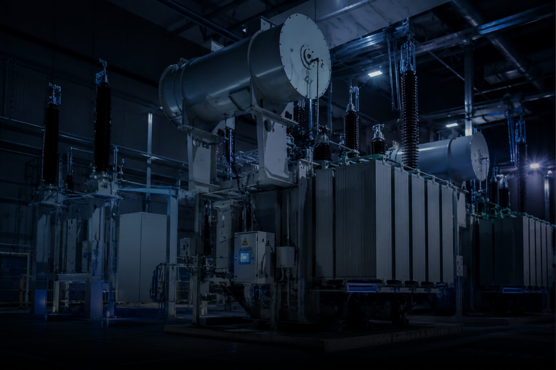 Power transformers in a dimly lit production hall